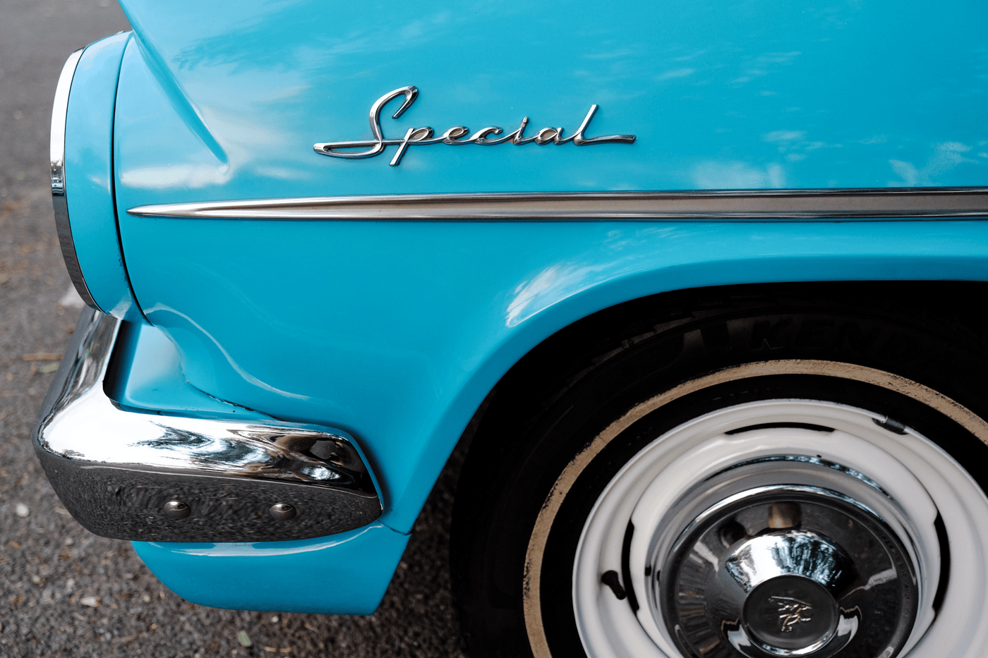 Close-up of a blue Holden Special classic car, featuring chrome details and whitewall tires.